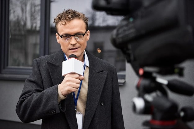 A close-up shot of a director on set, intensely focused while reviewing footage on a monitor. The lighting is low and dramatic, highlighting the director's concentration. In the background, there are crew members working and adjusting equipment.